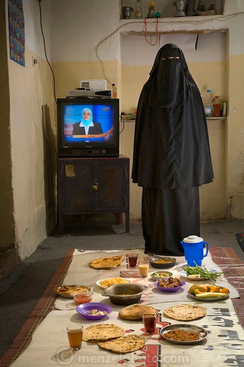 Saada Haidar, a housewife, with her typical day's worth of food at her home in the city of Sanaa, Yemen. (From the book What I Eat: Around the World in 80 Diets.) The caloric value of her day's worth of food in the month of April was 2700 kcals. She is 27 years of age; 4 feet, 11 inches tall; and 98 pounds. In public, Saada and most Yemeni women cover themselves for modesty, in accordance with tradition. MODEL RELEASED.