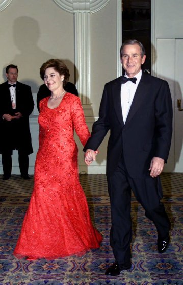 President and Mrs. Bush smile as they are welcomed by supporters at the Salute to Heroes and Veterans Banquet in Washington, Saturday, Jan. 20, 2001. (AP Photo/Doug Mills)