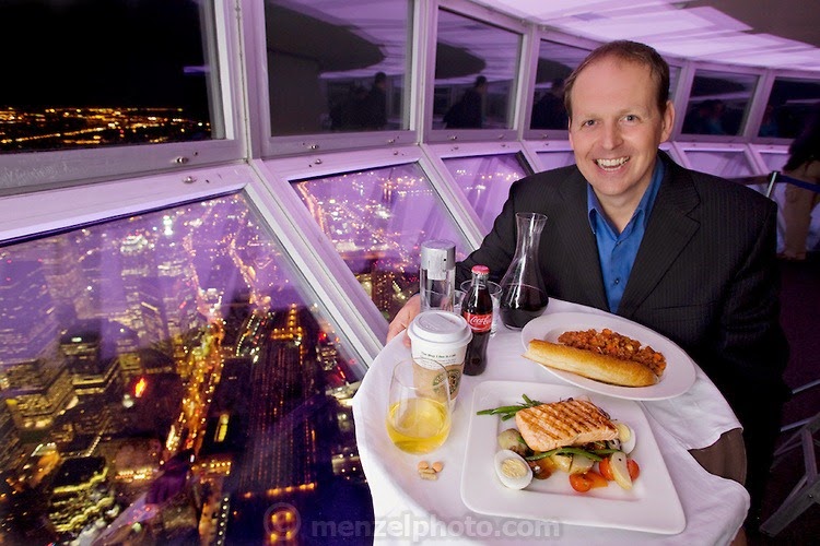 Neil Jones, the Director of Operations at the CN Tower in Toronto, Canada, with one day's worth of his typical food in the skypod of the tower. (From the book What I Eat: Around the World in 80 Diets.) The caloric value of his day's worth of food on a typical day in June was 2600 kcals. He is 44 years of age; 6 feet, 2 inches tall and 220 pounds. The viewing platform is above the world’s highest revolving restaurant, which revolves 360 degrees. The award-winning restaurant has awe-inspiring views and, for a tourist destination, surprisingly excellent food. The pricey entrance and elevator fee of about $25 per person is waived if you eat at the restaurant, making it cheaper to have lunch than to just see the sights. MODEL RELEASED.