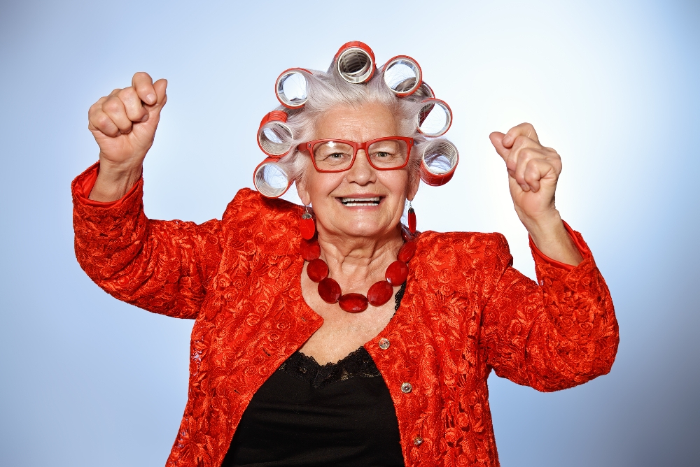 Portrait of an elderly woman in curlers looking at camera. 